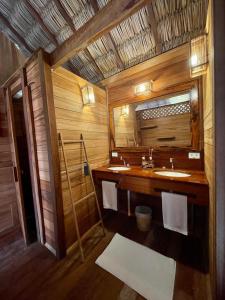 a bathroom with a sink and a mirror at Pousada Casa Caju Bangalows in Cumbuco