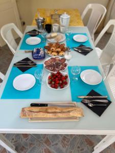 a blue table with plates and food on it at Chambre d'hôtes Casa Tib in Prunelli-di-Fiumorbo