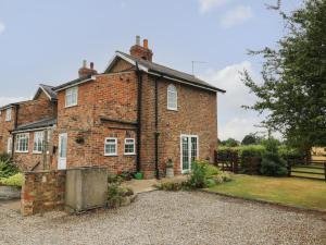 an old brick house with a gravel driveway at 2 Crosslands in York