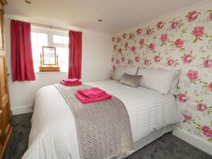 a bedroom with a bed with pink towels on it at 2 Crosslands in York