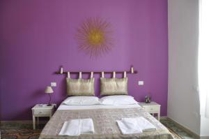 ein lila Schlafzimmer mit einem Bett und einer lila Wand in der Unterkunft Sisters house in Lecce