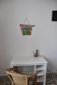 einen Schreibtisch mit einem Korbstuhl neben einem weißen Schreibtisch in der Unterkunft Sisters house in Lecce
