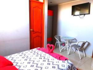 1 dormitorio con 1 cama, mesa y sillas en Amaris Hotel en Ica