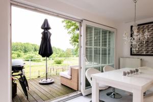 ein weißes Esszimmer mit einem weißen Tisch und einem Fenster in der Unterkunft Traumferienwohnung in der Lüneburger Heide in Soltau
