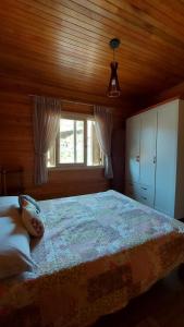 ein Schlafzimmer mit großem Bett und Fenster in der Unterkunft Refúgio do Lago in São Joaquim