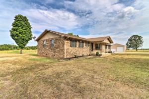 a stone house in a field with a tree at Charming Mountain Home Getaway with Gas Grill! in Mountain Home