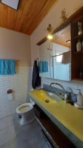 ein Badezimmer mit einem gelben Waschbecken und einem WC in der Unterkunft Refúgio do Lago in São Joaquim