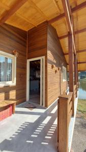 einen Außenblick auf ein Holzhaus mit einer Veranda in der Unterkunft Refúgio do Lago in São Joaquim + 5 Fotos