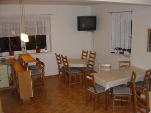 a dining room with tables and chairs and a tv at Vila Kamila in Janske Lazne
