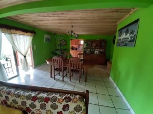 a living room with green walls and a table and chairs at LA MARINA in Ambodifototra
