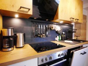 a kitchen with a stove and a counter with utensils at Upland Apartments - Fewo Waldgeist (inkl. MeineCardPlus) in Willingen +40 photos