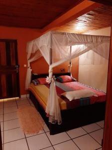 ein Schlafzimmer mit einem Himmelbett in der Unterkunft LA MARINA in Ambodifototra