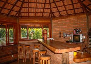 a kitchen with a bar and stools in a cabin at Chale Canto dos Cristais in Visconde De Maua