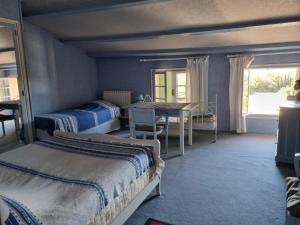 1 Schlafzimmer mit 2 Betten, einem Tisch und einem Fenster in der Unterkunft LES CONILS - Gites et Chambres d'hotes in Saint-Pierre-de-Vassols