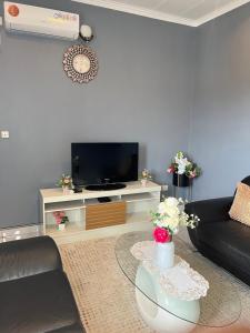 a living room with a couch and a tv at Studio de haut standing, Bonamoussadi (Kotto) in Douala +9 photos