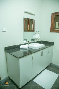 uma casa de banho com um lavatório e um espelho em CWEZI BY THE LAKE em Entebbe
