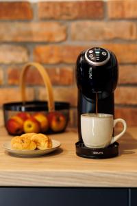 a coffee maker sitting on a counter with a cup of coffee at Stylowe apartamenty in Charzykowy