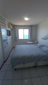 een slaapkamer met een groot bed en een raam bij STUDIO EM FORTALEZA NO CONDOMINIO VILA DE IRACEMA in Fortaleza