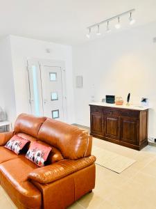 brązowa skórzana kanapa z dwoma poduszkami w obiekcie Villa Bella Luna with Pool - Puglia Mia Apartments w mieście Monopoli