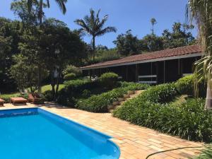 a swimming pool in front of a house at Lindo e aconchegante chalé com piscina, lareira e churrasqueira in São Roque