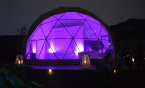 un violeta iluminando un iglú por la noche en Domo Suites Masía Cal Geperut, en Badalona