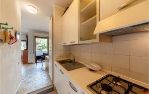 a kitchen with a sink and a stove top oven at 1 Bedroom Awesome Apartment In Stintino in Stintino