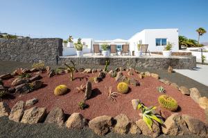 einen Garten mit Kakteen und Felsen vor einem Haus in der Unterkunft Sea Sky Lanzarote in Playa Blanca