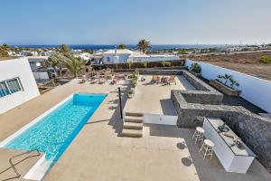 eine Villa mit einem Pool und einer Terrasse in der Unterkunft Sea Sky Lanzarote in Playa Blanca