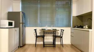 a kitchen with a table and two chairs and a refrigerator at Studio apartment in amazing location! 24h check-in in Tirana