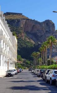 uma rua com carros estacionados em frente a uma montanha em Casa Domitilla Vista Mare - Spiagge, Storia & Relax Wifi - Netflix em Terracina