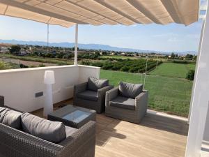 a patio with two chairs and a couch and a table at Casa Flamencos in Rojales