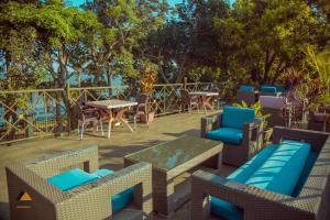 a patio with tables and chairs and a table at CWEZI BY THE LAKE in Entebbe