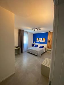 ein Schlafzimmer mit einem Bett und einer blauen Wand in der Unterkunft La Corte del Sole in Vieste