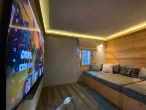 Camera con divano e TV a schermo piatto. di Chalet 7 Luxury Chalet with Cinema room a Crans-Montana