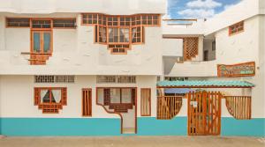 a facade of a house with wooden windows at Galapagos Native in Puerto Ayora