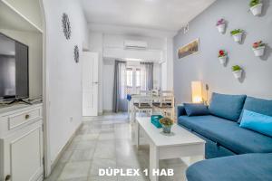 a living room with a blue couch and a table at Casas Caballerizas Mezquita 1 y 3 HAB in Córdoba