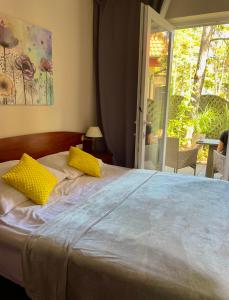 um quarto com uma cama com almofadas amarelas e uma janela em Morska Fala em Pobierowo