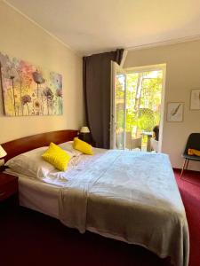 1 dormitorio con 1 cama grande con almohadas amarillas en Morska Fala, en Pobierowo