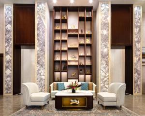a lobby with two chairs and a table and a book shelf at Blossom Hotel Houston in Houston