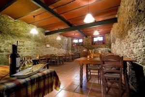 - une salle à manger avec une table, des chaises et une bouteille de vin dans l'établissement Casa Rural Finca Valvellidos, à Jaraiz de la Vera