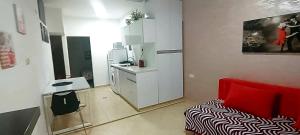 a small room with a red couch and a kitchen at Hotel Apartment Short Term Tel Aviv Bat Yam 353 in Bat Yam