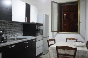 a kitchen with a table and a white refrigerator at B&B Cosenza in Cosenza