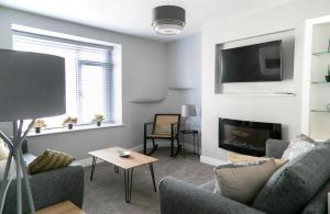 a living room with a couch and a fireplace at Siegfried's Retreat in Grassington