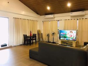 uma sala de estar com um sofá e uma televisão de ecrã plano em I'M Inn - Iconic Mardini Inn em Sorsogon