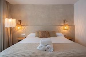 1 dormitorio con 1 cama con toallas en Hostal Es Niu de Tamariu, en Tamariu