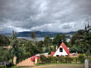 a red and white house with a view of a lake at TOSCANA de Tomine in Guatavita