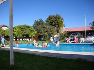 a group of people playing in a swimming pool at Laguneclub - Su casa de campo in Frutillar