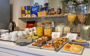 een buffet met verschillende soorten eten op de balie bij Hotel La Pace in Viareggio