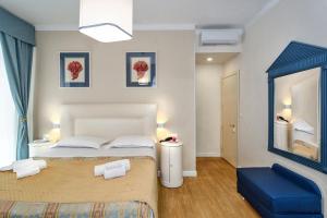 - une chambre avec un lit et une chaise bleue dans l'établissement Hotel La Pace, à Viareggio