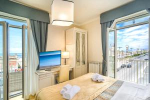 una camera con letto, TV e finestra di Hotel La Pace a Viareggio